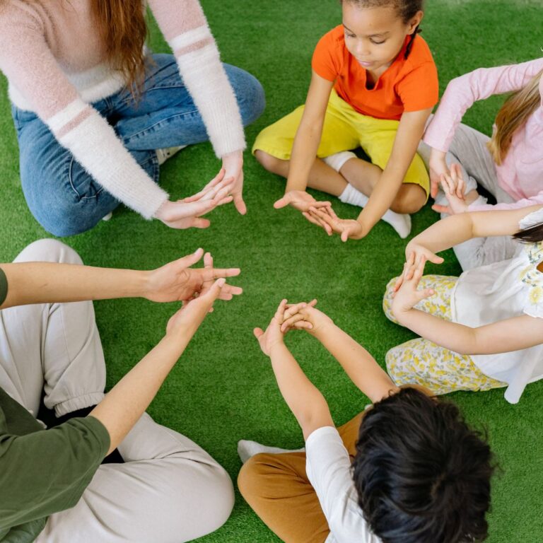 grupo de ninos con profesora haciendo ejercicio en circulo